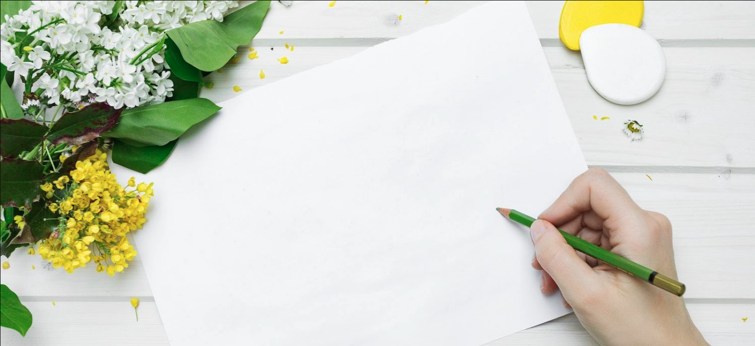 writing desk with blank page surrounded by flowers